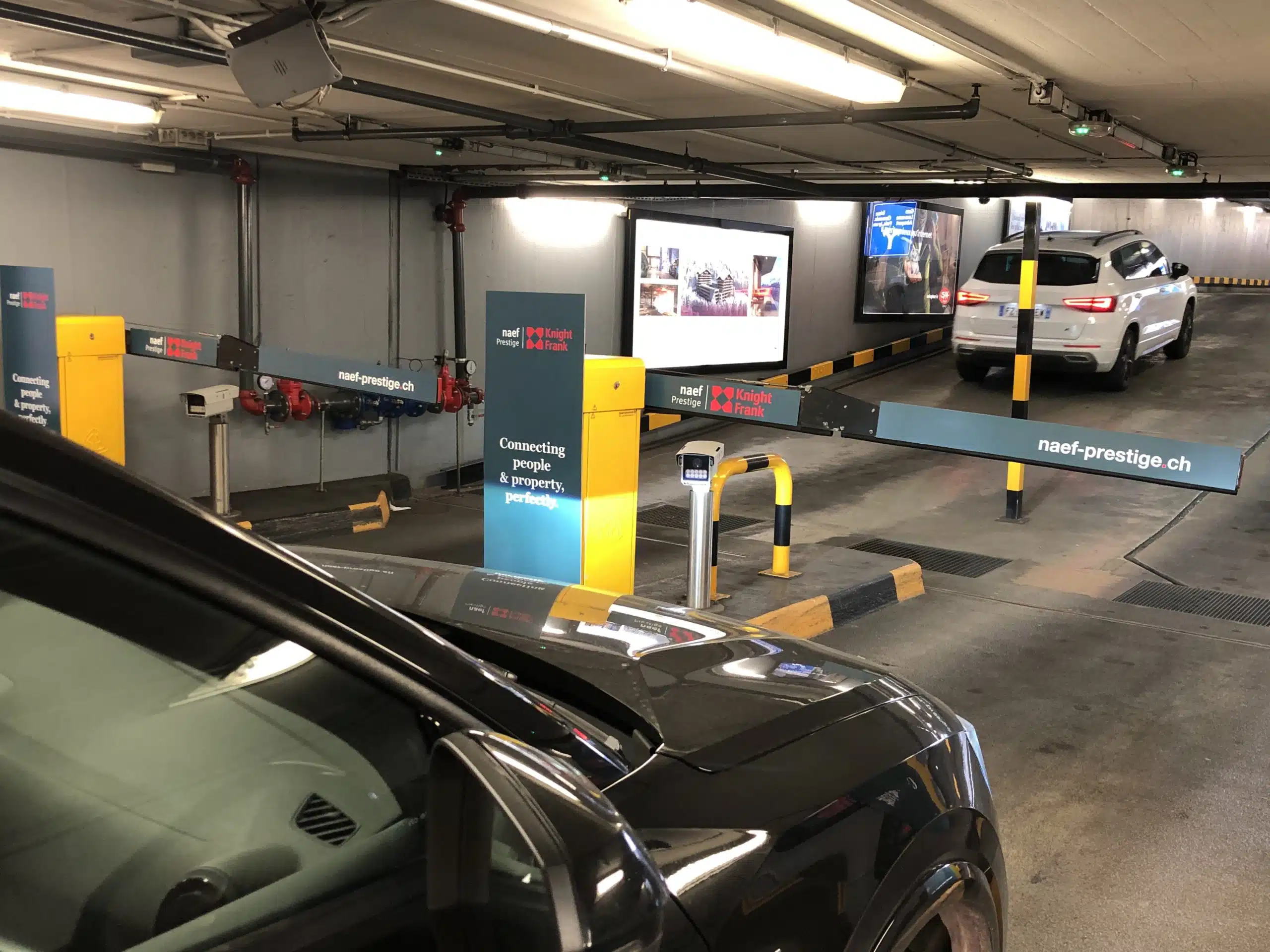 Campagne immobilière haut de gamme pour Naef Prestige | Knight Frank, apposée sur les bornes et bras de barrières du parking du Mont-Blanc à Genève.