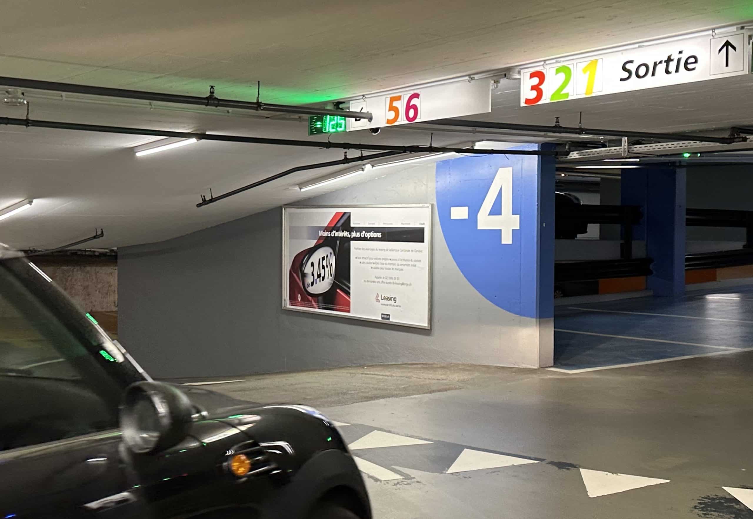 Large-format F12 billboard installed in the Villereuse car park in Geneva's Eaux-Vives district, offering maximum visibility to motorists and pedestrians.