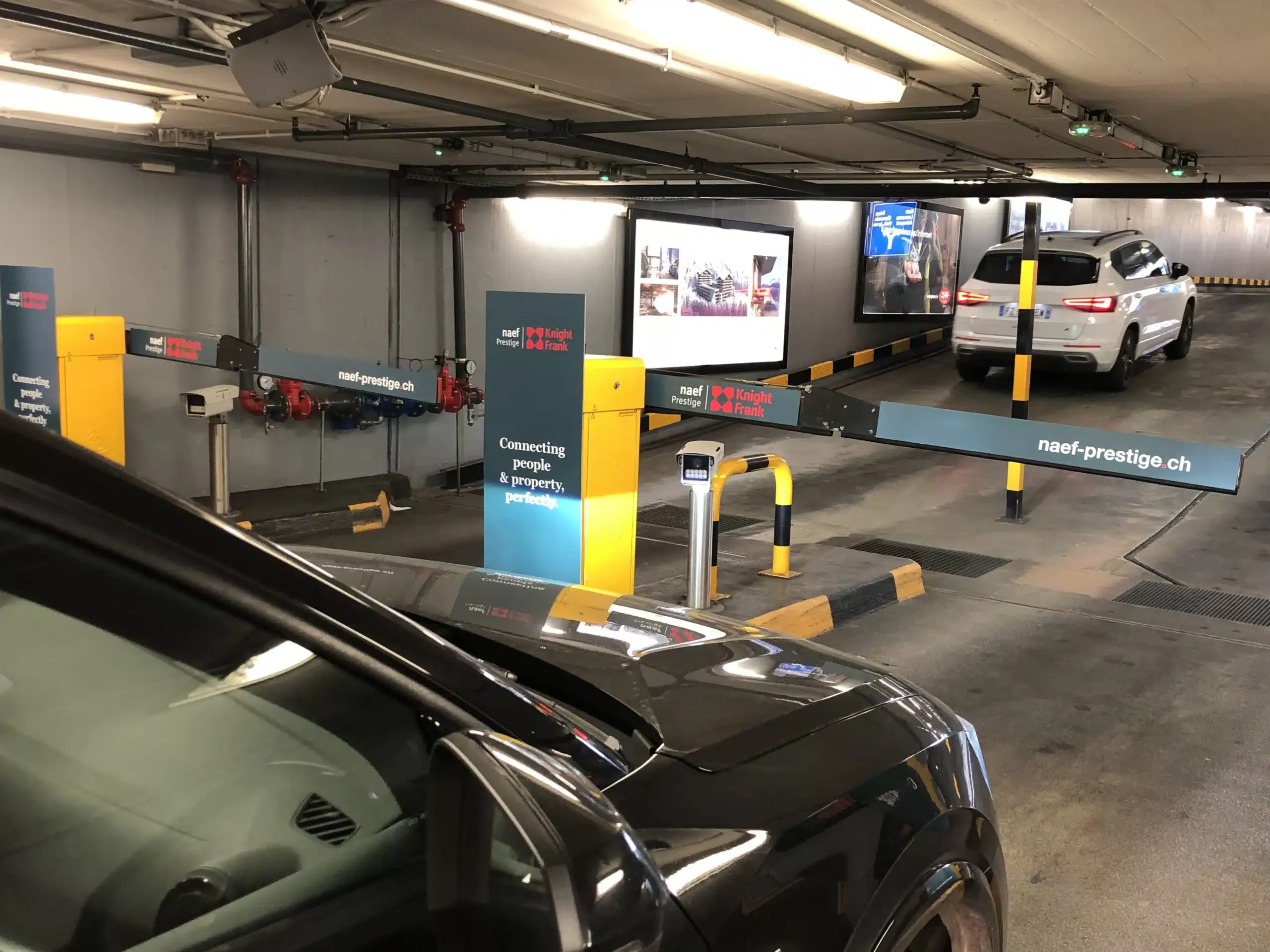 Campagne immobilière haut de gamme pour Naef Prestige | Knight Frank, apposée sur les bornes et bras de barrières du parking du Mont-Blanc à Genève.
