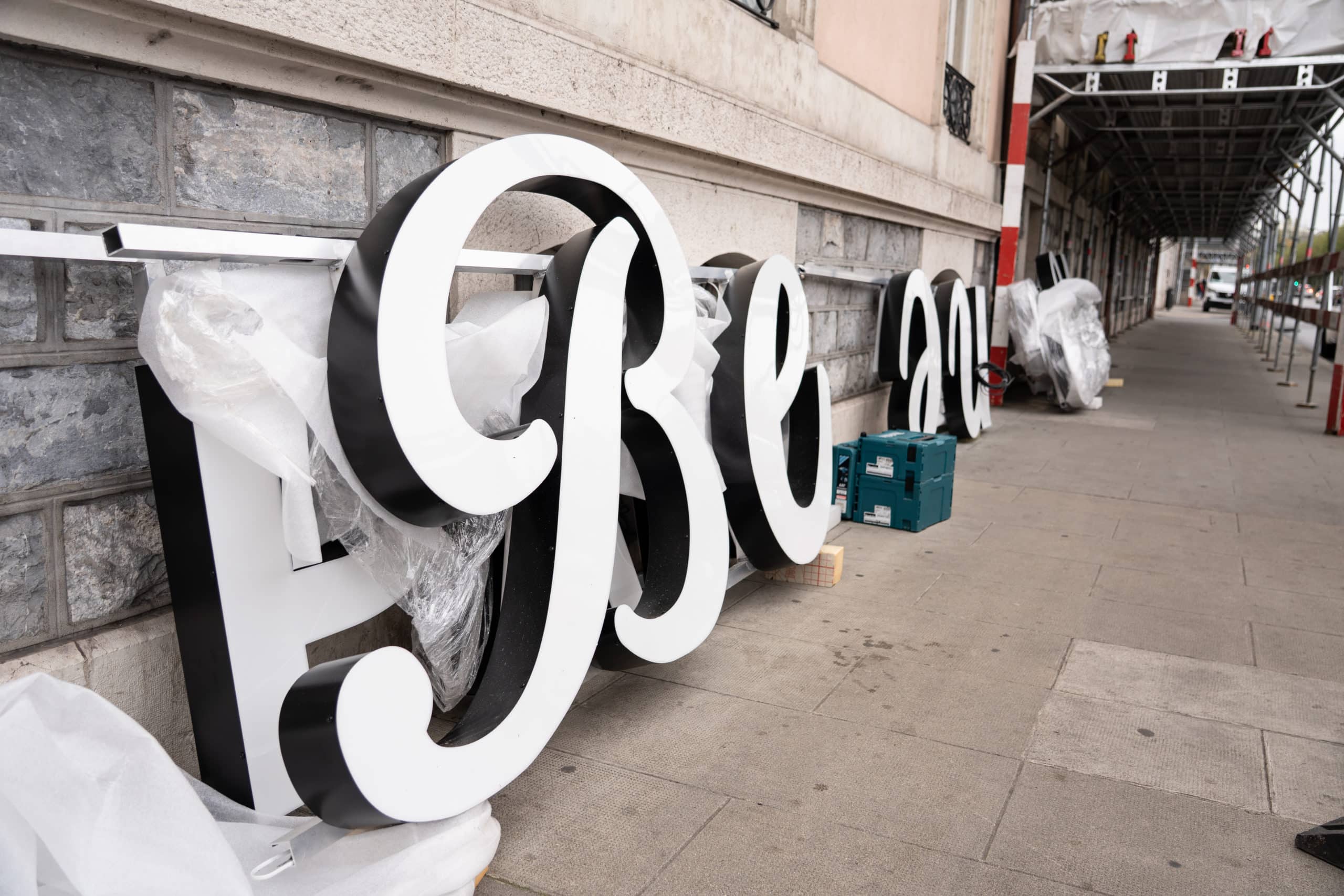Large ground-mounted illuminated sign ready for installation on a roof in Geneva