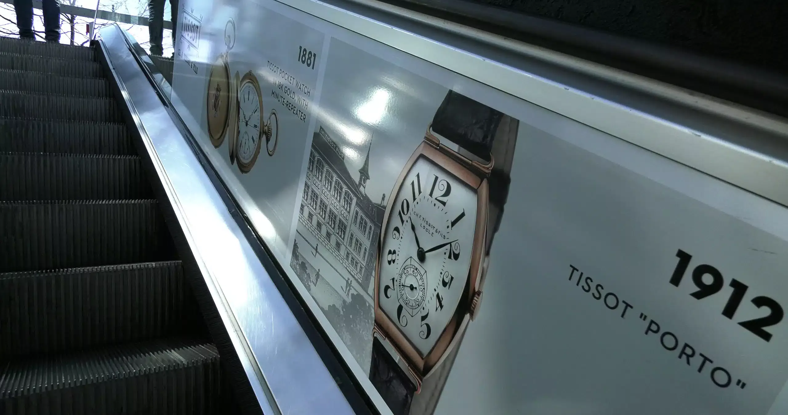 Covering publicitaire premium pour la marque horlogère Tissot sur les escalators du parking du Mont-Blanc, côtés Molard et Fusterie à Genève, réalisé par Force Promotion pour une visibilité stratégique en zone urbaine à fort trafic