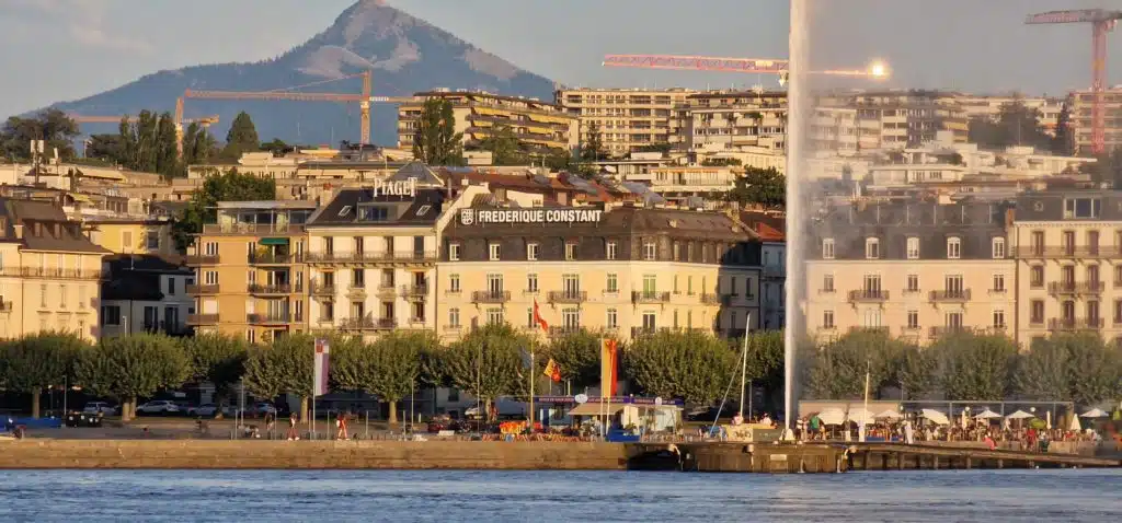 Vue sur le quai Gustave-Ador à Genève, face au Jet d’eau, avec les enseignes lumineuses en toiture installées par Force Promotion sur les toits des immeubles