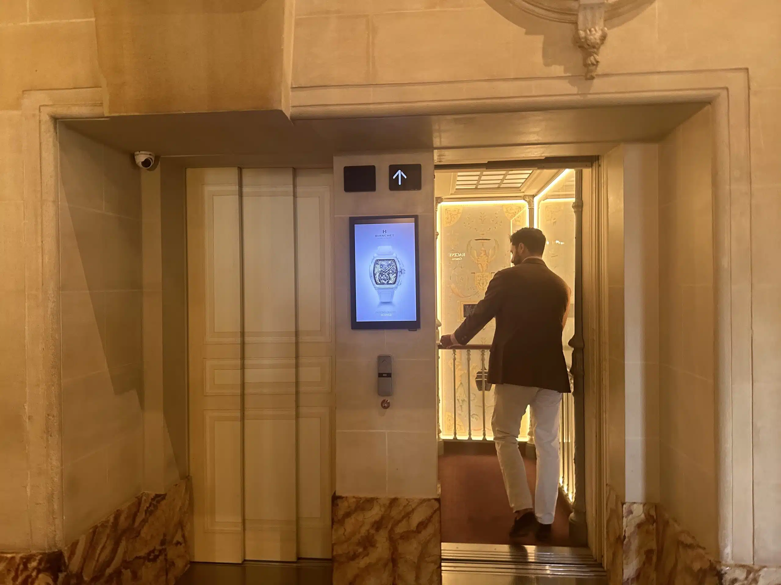 Écran d’affichage digital positionné à côté des ascenseurs dans l’hôtel Beau-Rivage à Genève, installé par Force Promotion pour capter l’attention d’une clientèle exclusive en déplacement