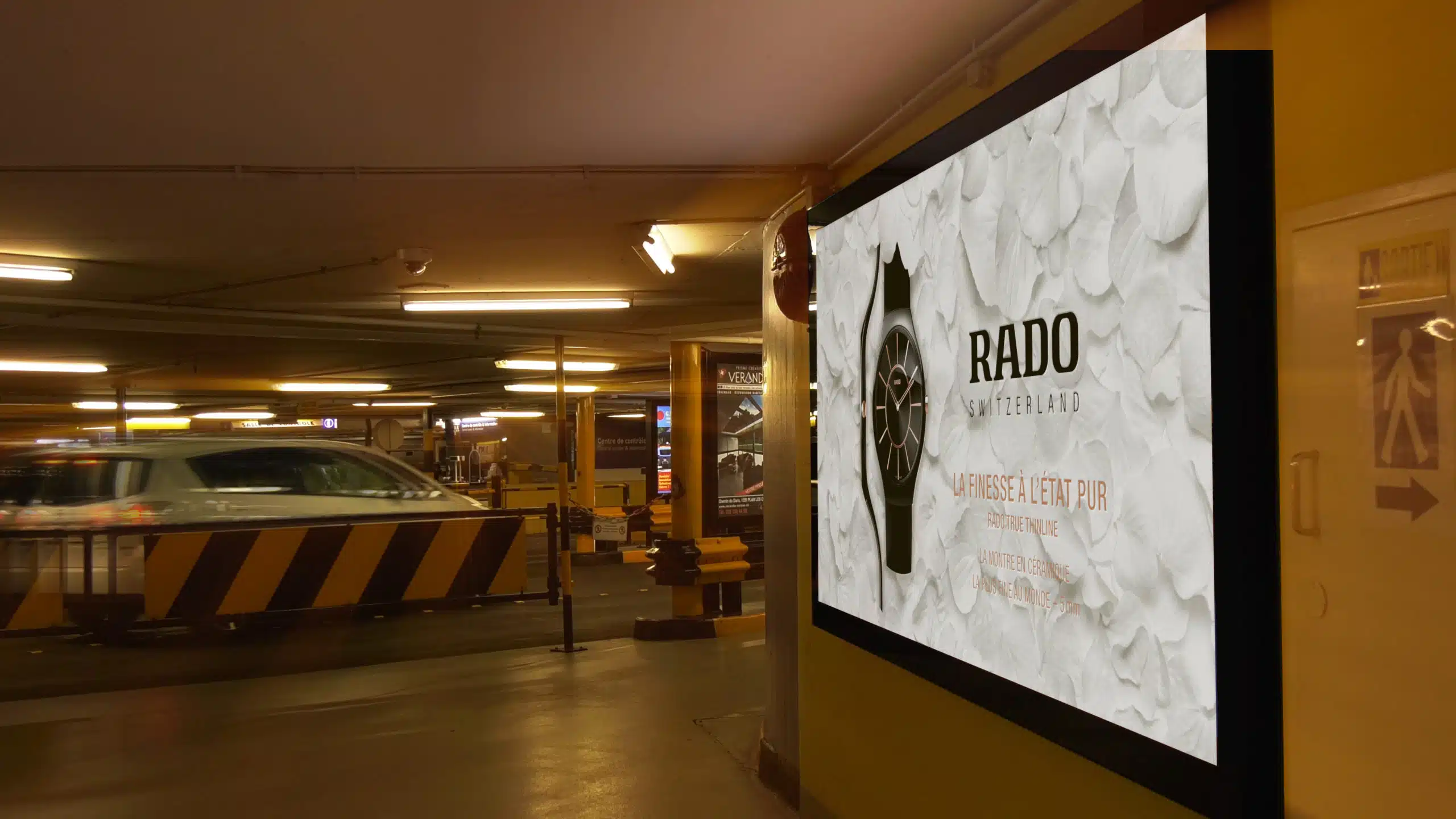 Affiche publicitaire Rado au format F12 installée par Force Promotion dans le parking du Mont-Blanc à Genève, pour une visibilité ciblée auprès d’un public urbain et mobile