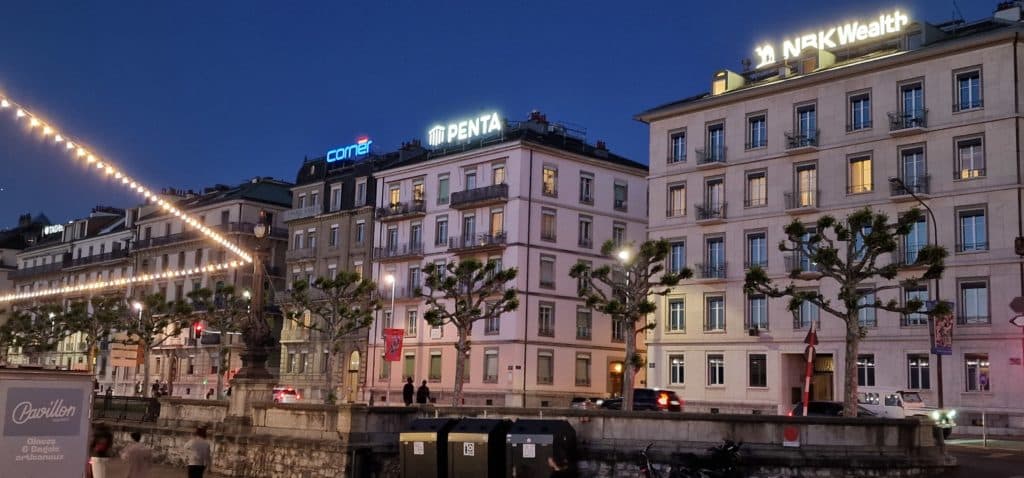 Enseigne lumineuse de nuit sur le toit du 4 quai Gustave-Ador à Genève, visible depuis la rade