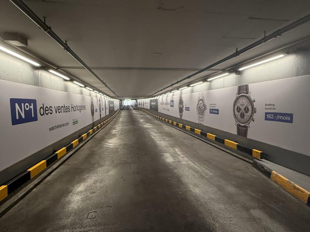 Mégaposters grand format face à face pour la campagne Watch Dreamer, installés en sortie Rive droite du parking du Mont-Blanc à Genève, visibles depuis les bannières.