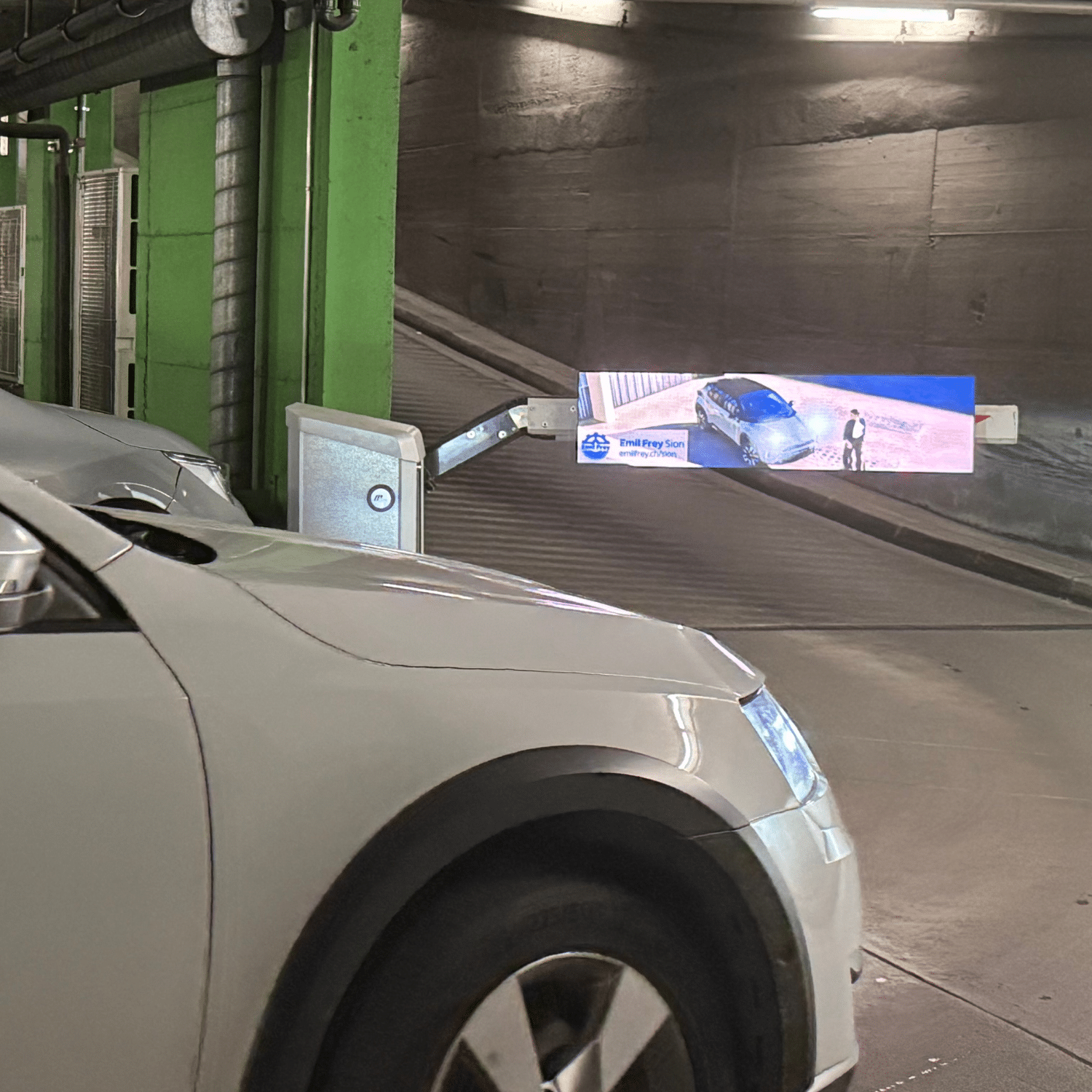 Barrières automatiques du Parking Manor à Sion, emplacement publicitaire idéal offrant une visibilité directe auprès des automobilistes, résidents et visiteurs du centre commercial.
