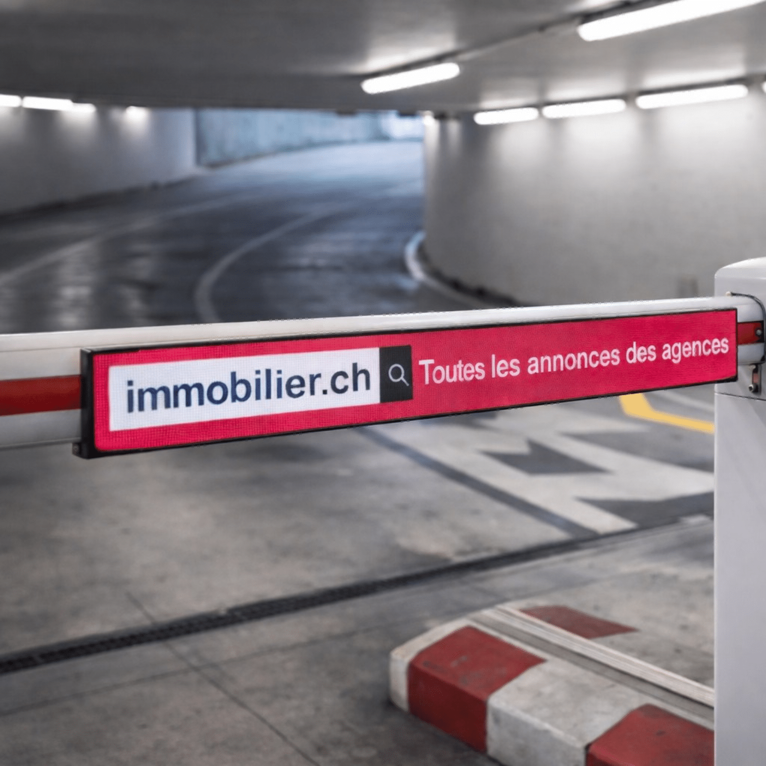 Publicité LED immobilier.ch affichée sur une barrière automatique à l’entrée du parking du Port d’Ouchy à Lausanne, avec le message « Toutes les annonces des agences ».