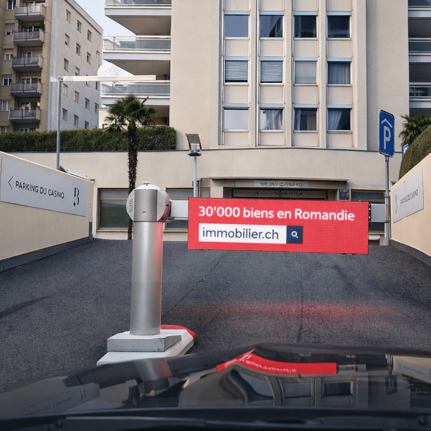 Écran publicitaire LED immobilier.ch affiché à l’entrée du parking du Casino de Montreux, visible depuis la voie d’accès automobile, avec le message « 30’000 biens en Romandie ».