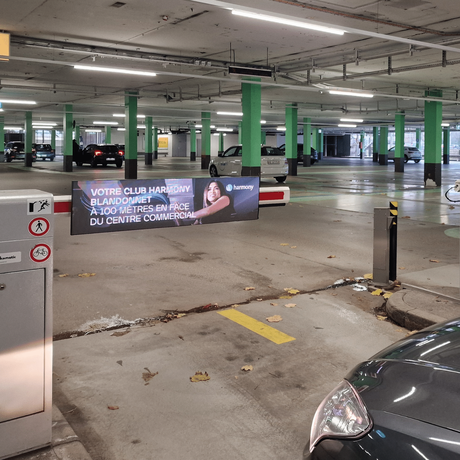 Spot publicitaire Black Friday Harmony Fitness sur les barrières digitales publicitaires du parking du centre commercial Blandonnet à Vernier, canton de Genève