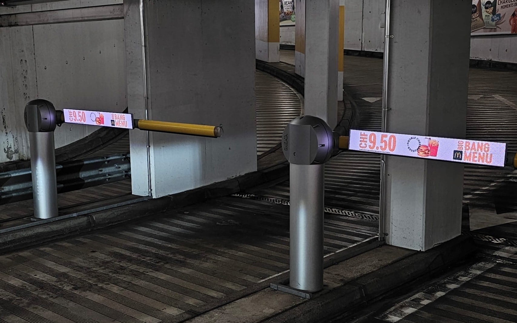Écran digital affichant une publicité sur le bras de la barrière d’entrée du parking Pont Neuf à Morges, visible par les automobilistes - Mc Donalds
