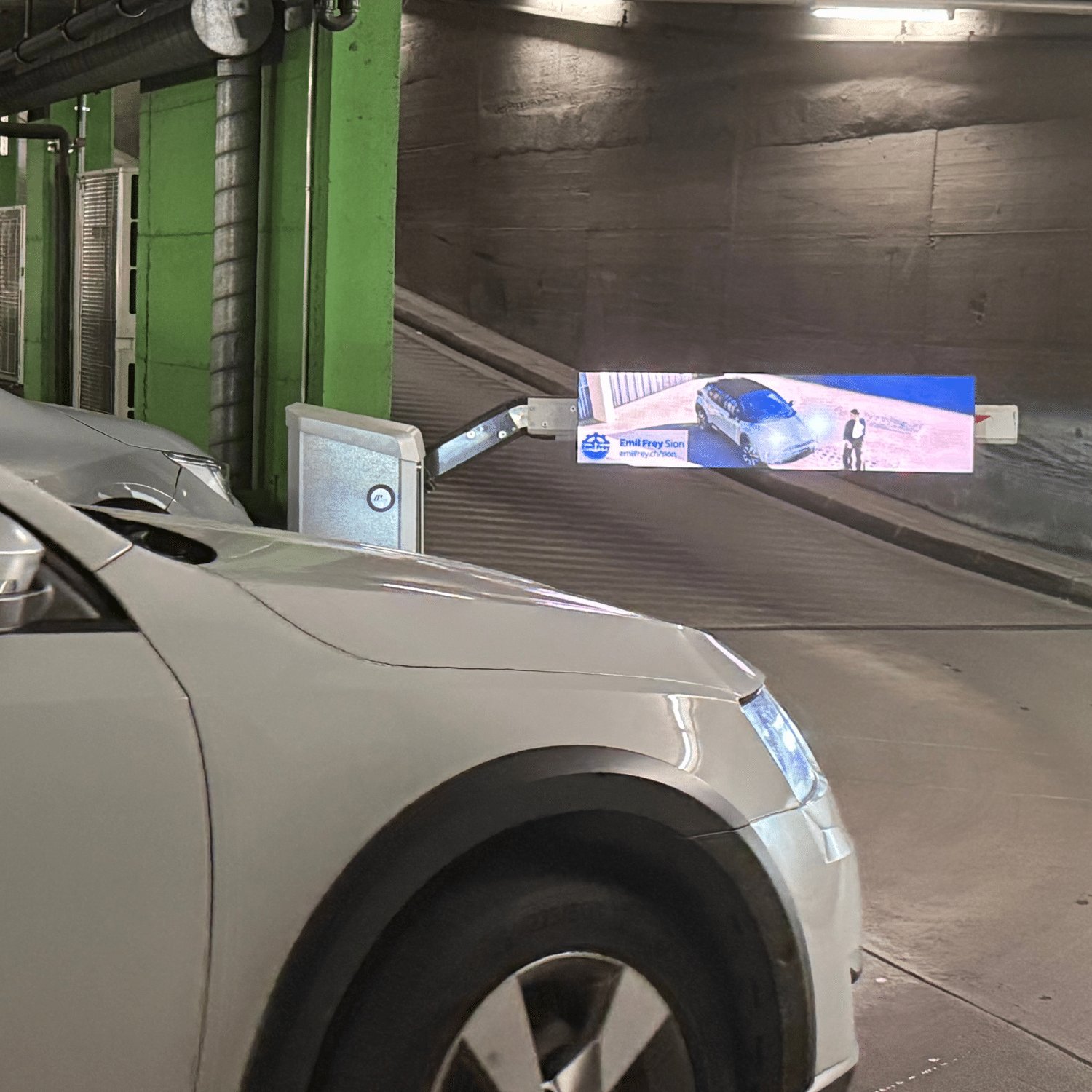 Barrières automatiques du Parking Manor à Sion, emplacement publicitaire idéal offrant une visibilité directe auprès des automobilistes, résidents et visiteurs du centre commercial.