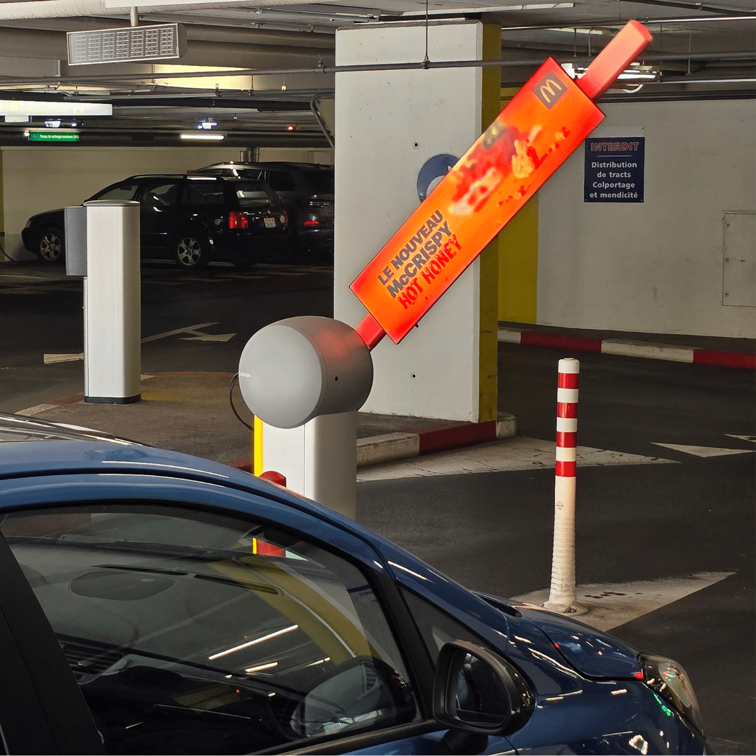 Vue rapprochée des barrières LED du Parking Bellefontaine à Lausanne, support publicitaire moderne et lumineux visible des conducteurs et passants.