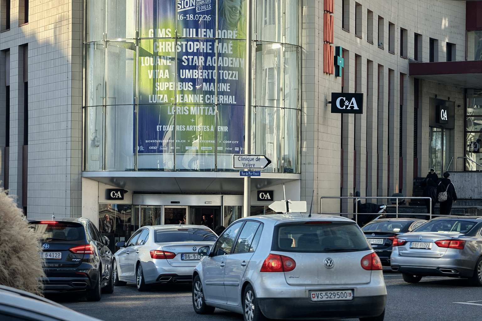Mégaposter publicitaire rétroéclairé installé sur la façade du C&A à Sion, face au giratoire principal, mettant en avant l’événement Sion sous les étoiles produit par Live Music Production.