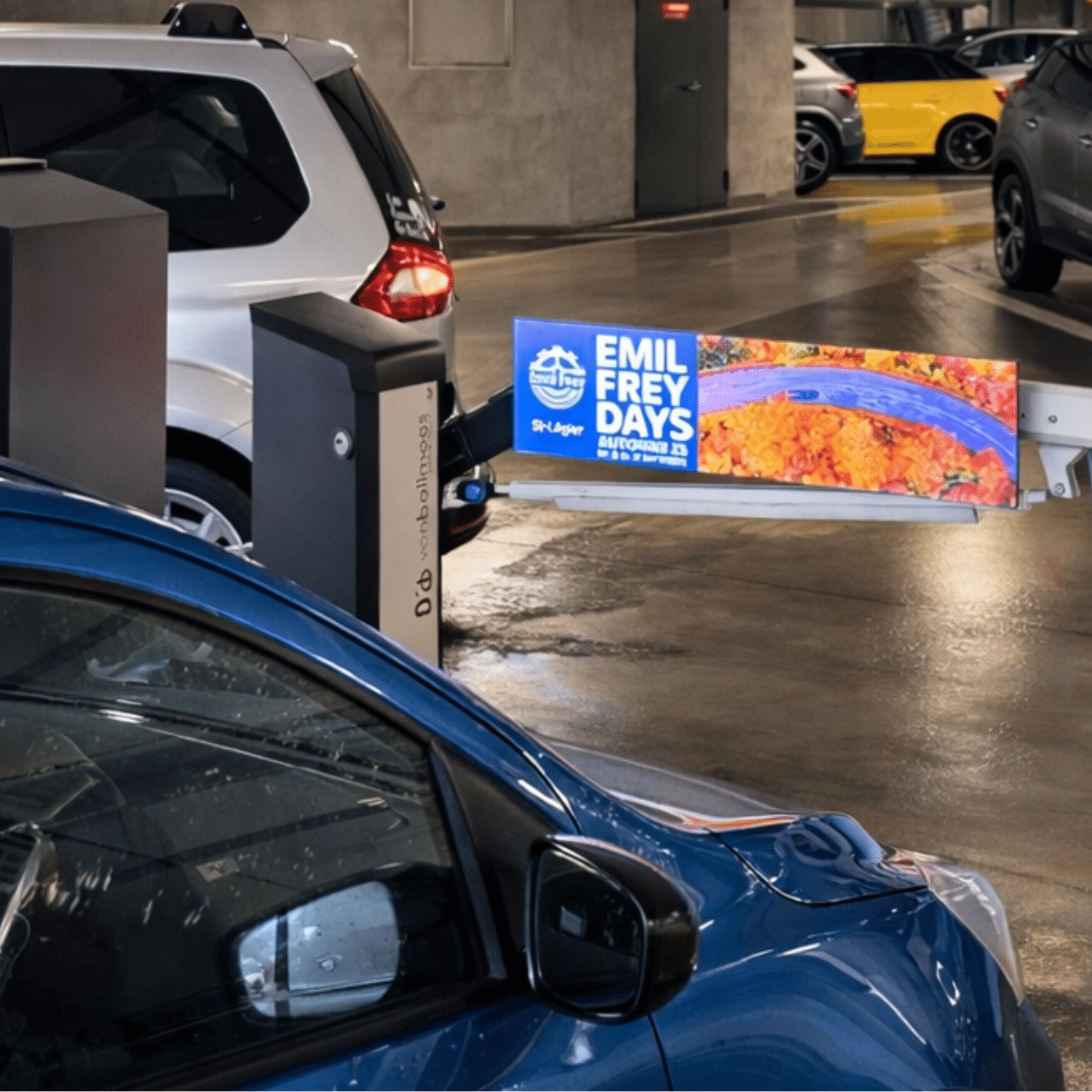 Barrières publicitaires LED installées au Parking des Remparts à La Tour-de-Peilz, diffusant la campagne Emil Frey Saint-Légier dans un parking couvert, visibles à l’entrée des véhicules.