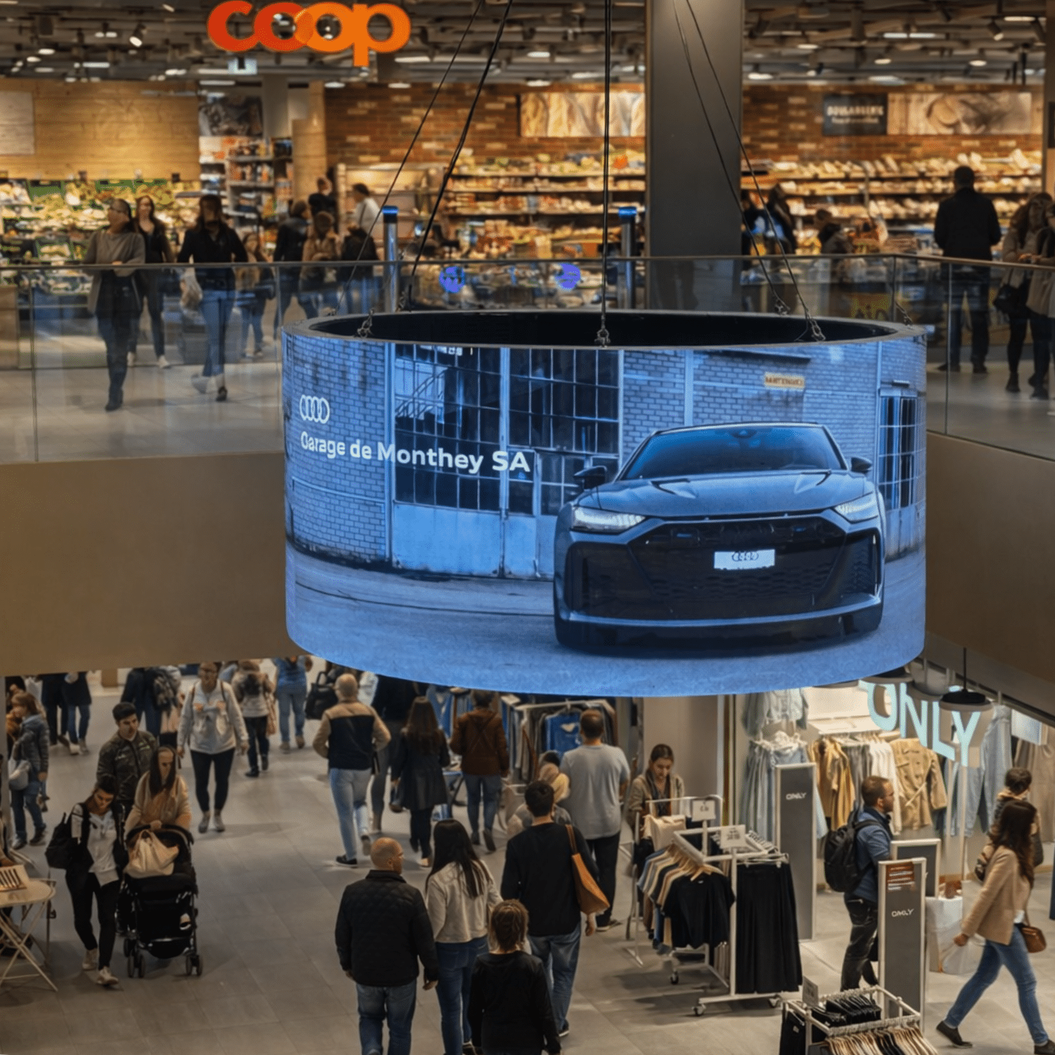 Vue de l’écran digital 360° MCentral à Monthey, implanté au centre commercial MCentral, offrant une visibilité panoramique et un fort impact publicitaire auprès des passants. Publicité Garage de Monthey Audi