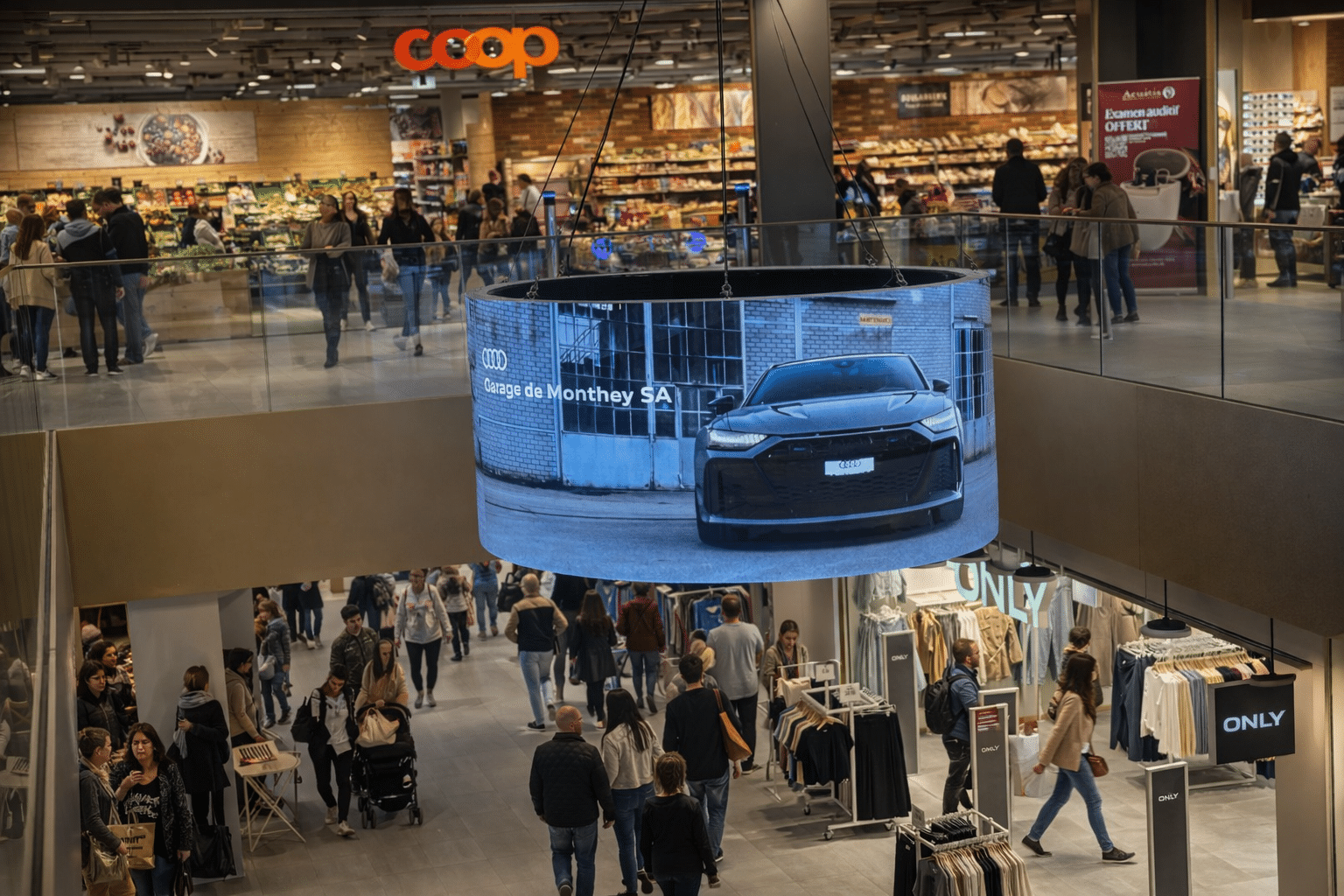 Vue de l’écran digital 360° MCentral à Monthey, implanté au centre commercial MCentral, offrant une visibilité panoramique et un fort impact publicitaire auprès des passants. Publicité Garage de Monthey Audi