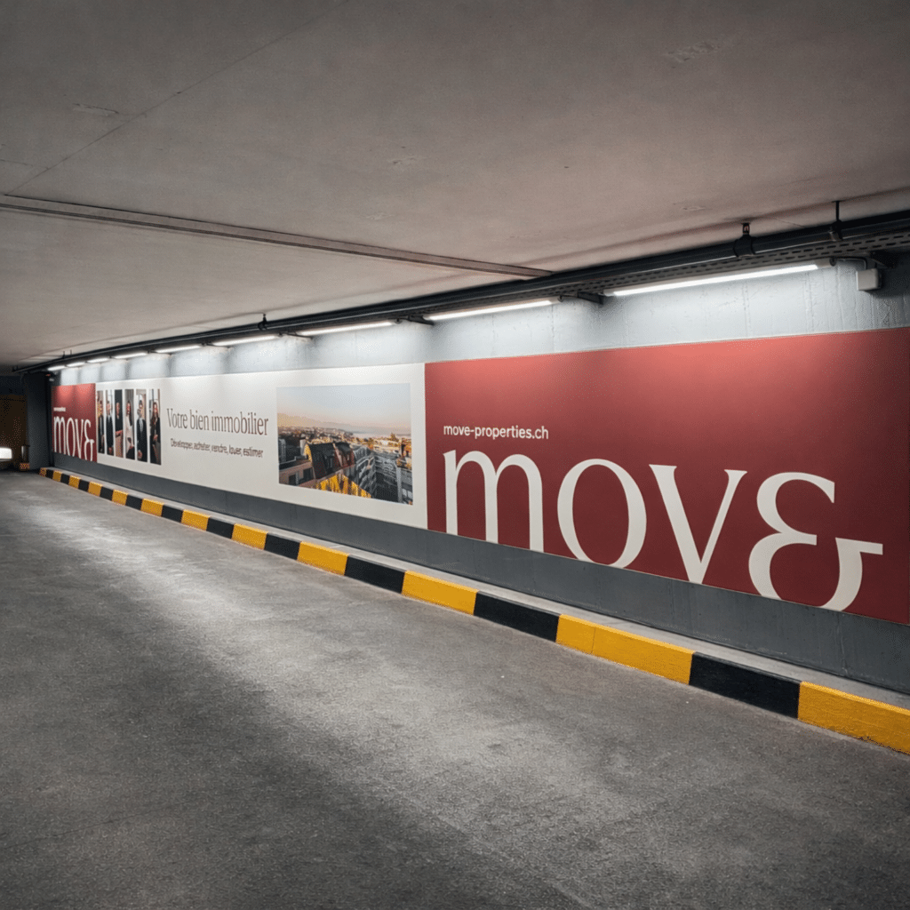 Grand mégaposter Moser Vernet & Cie installé sur la paroi de droite en sortie Rive Gauche du parking du Mont-Blanc à Genève, toile tendue rétroéclairée par LED, visible le long de la voie de circulation des véhicules.